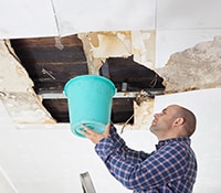 Man Checking for Leaks in Basement Ceiling